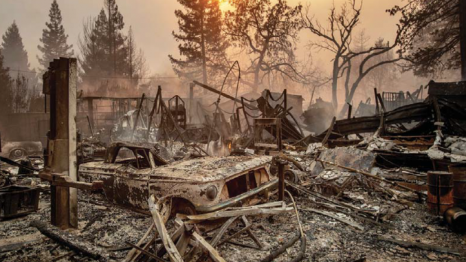 sits among the debris of a burned home as the Camp Fire tears through Paradise on Thursday. AP photo.