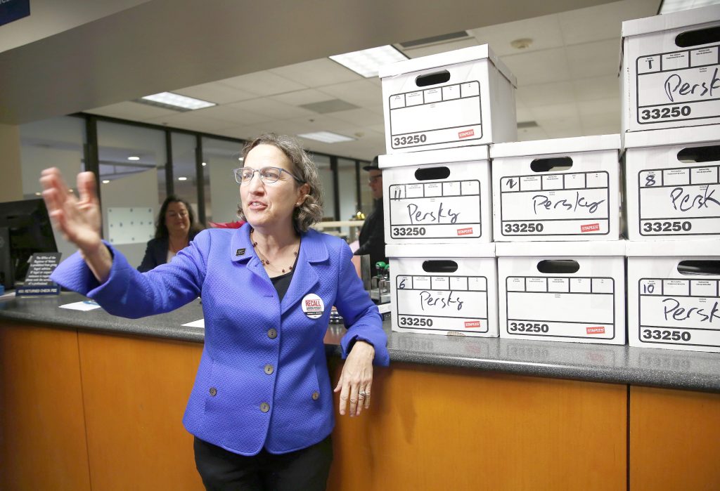 Michele Dauber, standing at the counter of the Registrar of Voters in San Jose on Jan. 11, gestures to supporters after handing over boxes containing signatures to place the recall of Santa Clara County Judge Aaron Persky on the June ballot.