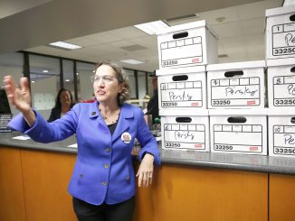 Michele Dauber, standing at the counter of the Registrar of Voters in San Jose on Jan. 11, gestures to supporters after handing over boxes containing signatures to place the recall of Santa Clara County Judge Aaron Persky on the June ballot.
