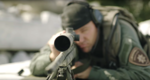 A police officer aims a rifle in a recruitment video.