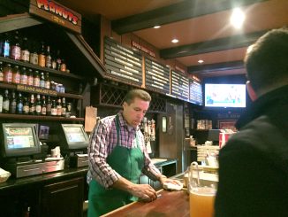 Juan Salazar behind the bar at the Oasis just before the place closed. He's been with the Oasis for 23 years. Post photo by Emily Mibach.