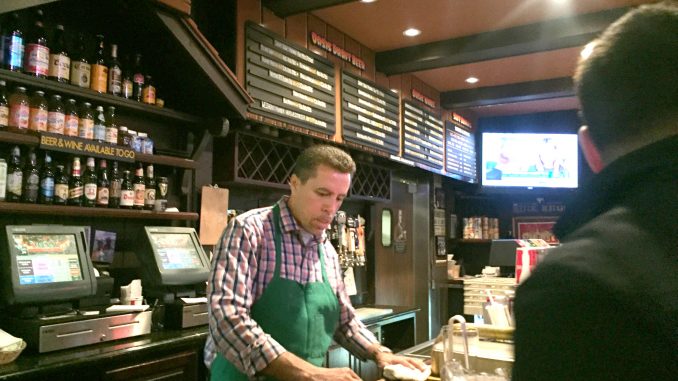 Juan Salazar behind the bar at the Oasis just before the place closed. He's been with the Oasis for 23 years. Post photo by Emily Mibach.