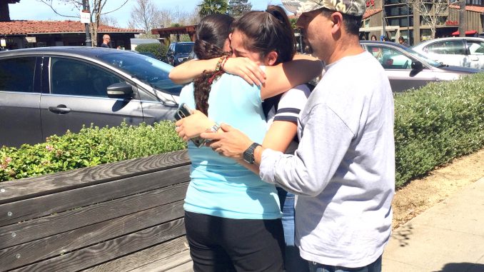 Palo Alto High School freshman Perla del Rio hugs her parents, Jose and Lupe del Rio, after the lockdown ended yesterday. Post photo by Allison Levitsky.