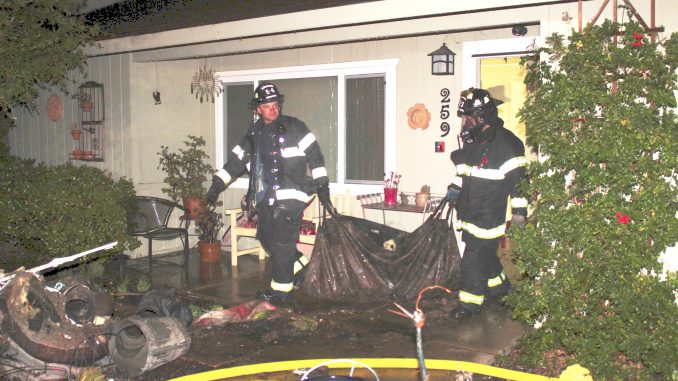 Firefighters remove damaged items from a house at 298 Beresford Ave. in unincorporated Redwood City. Photo provided by the Menlo Park Fire Protection District.