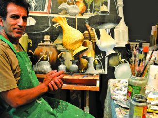 Artist Hadi Aghaee poses with his realistic acrylic painting titled “Remnant of the Coppersmith Bazaar.” He will show his art this weekend in Palo Alto.