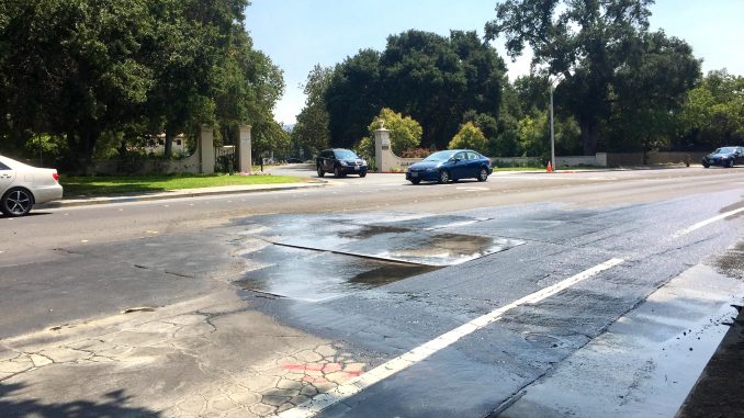 The leak is under these metal plates on Arastradero Road across from the entrance to Alta Mesa Memorial Park. Post photo.