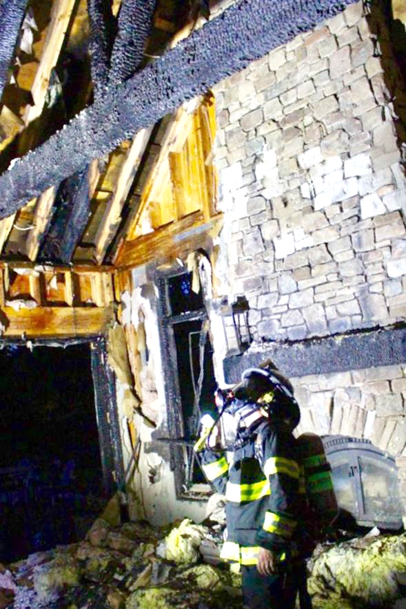 Menlo Park Fire Investigator David Perrone inspects  damage in the inside a home at 11 Robert S Drive. Photo by Peter Mootz.