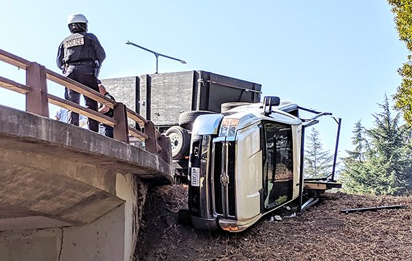 A Mountain View police officer looks at a gruck that overturned on Friday on Shoreline Boulevard. Photo submitted by Post reader Roger Noel.